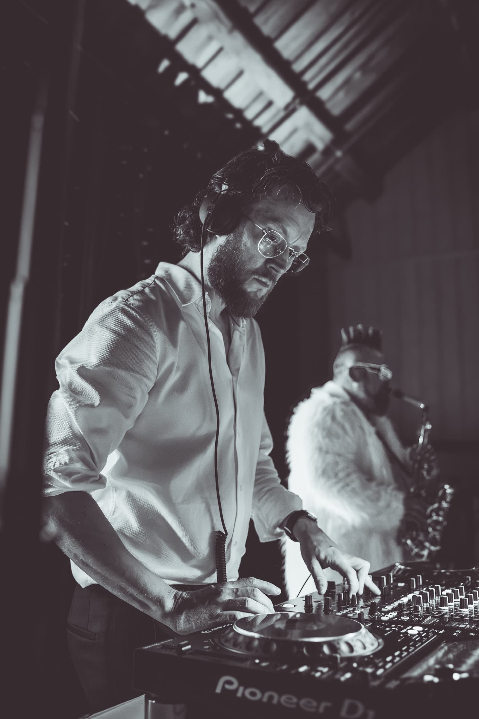 DJ ved miksepult og saksofonist spiller under en bryllupsfest