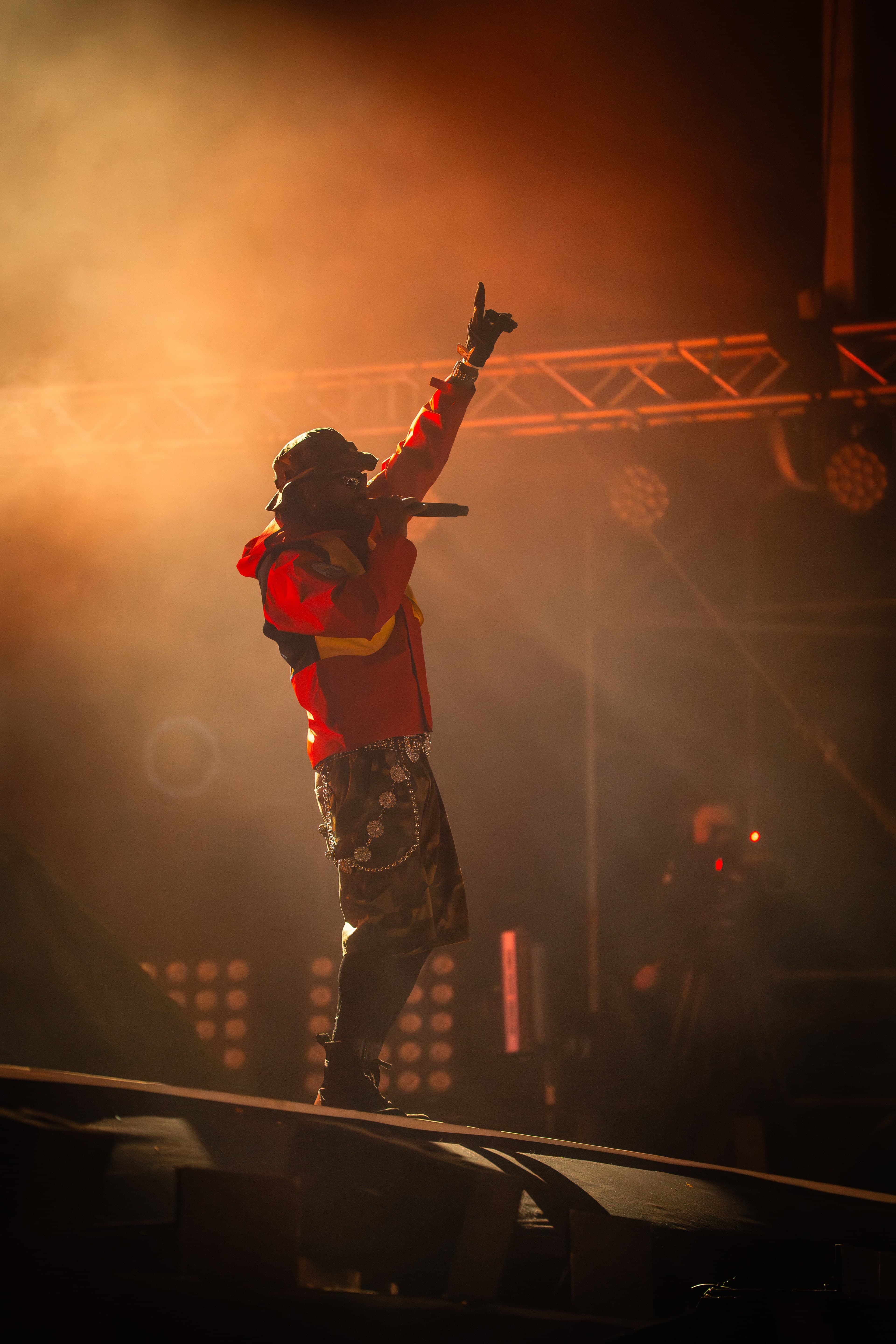 Artist på scenen under et konsertoppdrag for Eventshoot, med pyroteknikk og røyk i bakgrunnen